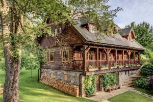 a log home with a wrap around porch and a deck at Silverstone Living in Semily