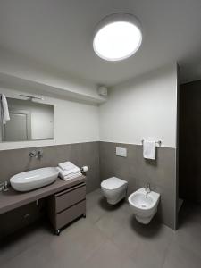 W łazience znajduje się umywalka, toaleta i lustro. w obiekcie Cascina Pianetta Quinta w mieście Missaglia