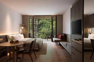 a hotel room with a bed and a desk and a table at Yangshuo Sugar House in Yangshuo