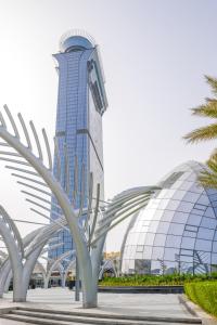 a tall building with a palm tree in front of it at Ultra Luxury Palm Tower with Shared 5 Star Hotel Facilities in Dubai