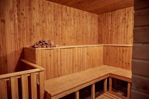 a wooden sauna with a bench and a pile of rocks at Hotel Royal (Отель Роял) in Poltava