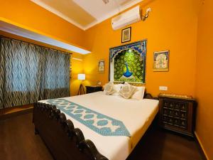 um quarto com uma cama grande e paredes amarelas em The Castle View Homestay em Bundi