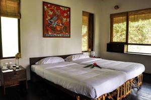 ein Schlafzimmer mit einem großen Bett mit einer Schleife darauf in der Unterkunft Uravu Bamboo Grove Resort in Wayanad