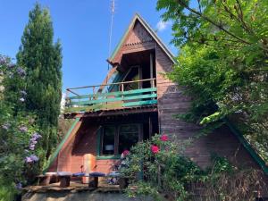Domek wakacyjny Lachertówka Ostrów Wielki في Gil Mały: منزل خشبي مع شرفة وزهور