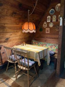 Domek wakacyjny Lachertówka Ostrów Wielki في Gil Mały: غرفة طعام مع طاولة وكراسي في كابينة