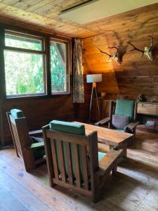 a dining room with a table and chairs in a cabin at Domek wakacyjny Lachertówka Ostrów Wielki in Gil Mały