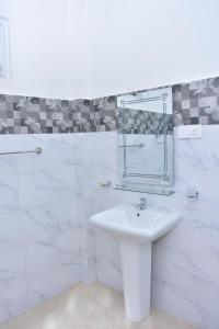 La salle de bains blanche est pourvue d'un lavabo et d'une douche. dans l'établissement Ceylon Relax Villa, à Moragalla