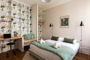 a bedroom with a bed and a desk with a laptop at Appartement Dify Deruelle - Part Dieu in Lyon