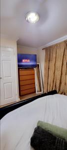 a bedroom with a bed and a tv and a window at 2 Bedroom Apartment - Greater London in Dagenham