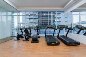 a gym with several treadmills and elliptical machines at Kasco Homes Waves Tower Business Bay in Dubai