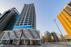 een hoog gebouw midden in een stad bij Kasco Homes Waves Tower Business Bay in Dubai