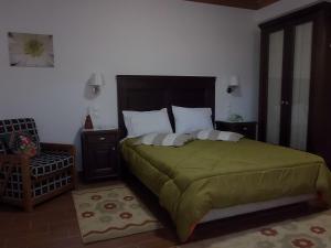 1 dormitorio con 1 cama grande y 1 silla en Petrino, en Méga Khoríon