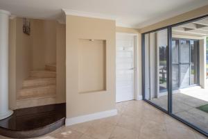 un pasillo con puertas correderas de cristal y una escalera en Ocean View Executive Apartment 2, en Busselton
