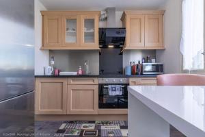 a kitchen with wooden cabinets and a counter top at Le Marbré design 60m2, 2 Stars, Free parking in Annemasse