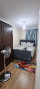 a bedroom with a bed with a fan and a rug at 2 Bedroom Apartment - Greater London in Dagenham