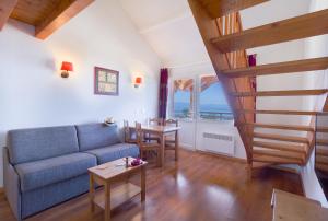 ein Wohnzimmer mit einem blauen Sofa und einem Tisch in der Unterkunft Garden & City Evian - Lugrin in Lugrin