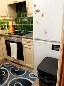a kitchen with a white refrigerator and a stove at 2 Bedroom Apartment - Greater London in Dagenham