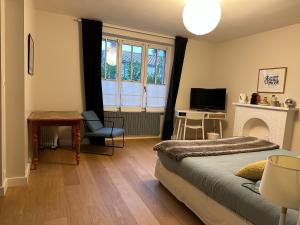 a bedroom with a bed and a desk and a television at La Pierre Percée - accès digicode in Vertou