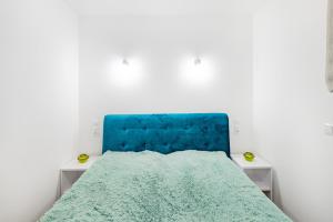 a bed with a blue headboard in a room at Apartament Ale Widok in Szczyrk