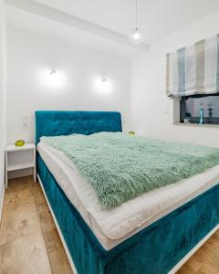 a large bed with a blue headboard in a bedroom at Apartament Ale Widok in Szczyrk