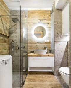 ein Bad mit einem Waschbecken und einem Spiegel in der Unterkunft Apartament Ale Widok in Szczyrk