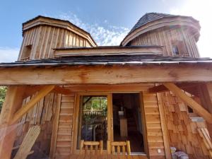 Cabaña de madera con 2 sillas en el porche en Roulottes au pied du Vercors, en Saint-Jean-en-Royans