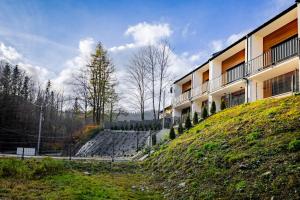 a building on a hill next to a building at Apartament Ale Widok in Szczyrk