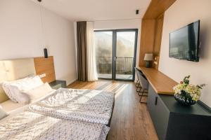 a bedroom with a bed and a desk and a television at Penzion Šterk in Most na Soči +107 photos