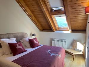 a bedroom with a bed with a purple blanket and a window at Àtic de luxe i rústic a Esterri d'Àneu by RURAL D'ÀNEU in Esterri d'Àneu