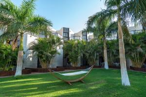 a hammock in front of a building with palm trees at Riviera by Isrotel Collection in Eilat