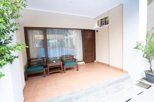 einen Balkon mit einem Tisch und Stühlen sowie einem Fenster in der Unterkunft New Sunari Lovina Beach Resort in Lovina