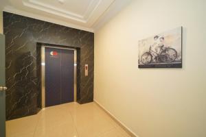 a hallway with a door and a picture of a bicycle on the wall at Avatel Jelutong PWCC in George Town