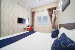 a hotel room with a bed and a tv at Avatel Jelutong in George Town