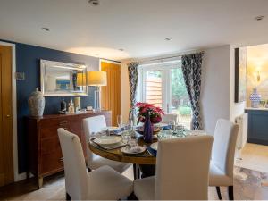 a dining room with a table and white chairs at Fairview Cottage in Moreton in Marsh