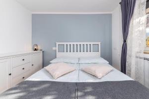 um quarto com uma grande cama branca com almofadas cor-de-rosa em Apartma Ivana & Ivanka em Bohinj