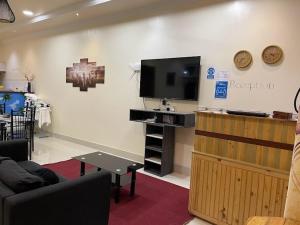 salon z telewizorem z płaskim ekranem na ścianie w obiekcie LETS GO HURAA w mieście Huraa