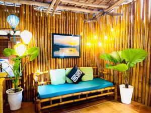 a bench in a bamboo room with two plants at Under The Coconut Tree Hoi An Homestay in Hoi An