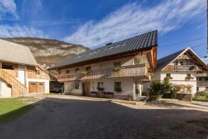 a large white house with a black roof at Apartma Ivana & Ivanka in Bohinj