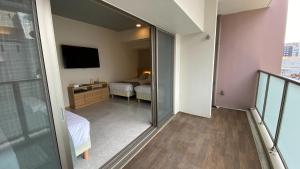 那霸Tabinoteitaku Okinawa Naha 2nd的客房设有阳台、一张床和电视。