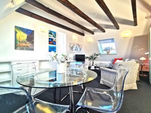 a living room with a glass table and chairs at Business-Apartment Ahrensburg in Ahrensburg