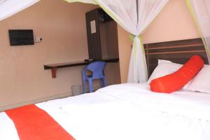 a bedroom with a bed with a red pillow at Good Morning Hotel Rongo in Paulo