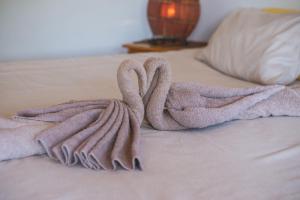 ein Bett mit zwei Handtüchern darüber in der Unterkunft Thokozani Lodge in White River