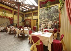 un restaurante con mesas blancas y sillas rojas y una pintura en Hotel Motel Del Duca, en Cava Manara