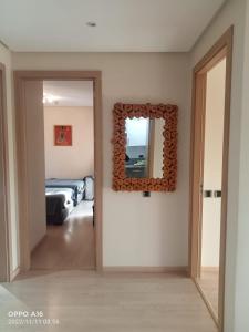 um quarto com um espelho na parede e uma cama em Appartement Prestigia Golf Marrakech em Marrakech
