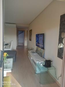 ein Wohnzimmer mit einem Sofa und einem Laptop auf einem Glastisch in der Unterkunft Appartement Prestigia Golf Marrakech in Marrakesch