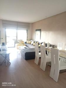 a living room with a couch and a table and chairs at Appartement Prestigia Golf Marrakech in Marrakesh