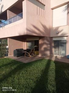 a house with a lawn in front of it at Appartement Prestigia Golf Marrakech in Marrakesh