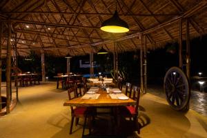 a dining room with a wooden table and a large wheel at AATHAVAN MATICHI ECO RESORT in Panhāla