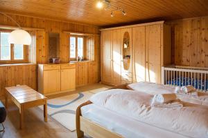 una camera da letto con pareti in legno, un letto e un tavolo di Haus Schmitten - Davos a Schmitten