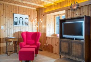 a living room with a red chair and a tv at Haus Schmitten - Davos in Schmitten
